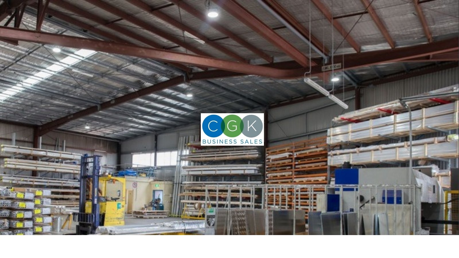 Industrial warehouse with storage racks, a forklift, and a CGK Business Sales sign, the kind of capital-intensive business affected by SBA loan changes in 2026